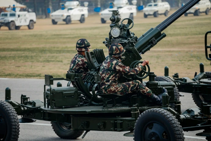 Soldiers operate a large artillery gun on a vehicle.